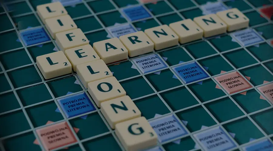 Scrabble game board with the words lifelong learning in Scrabble tiles.